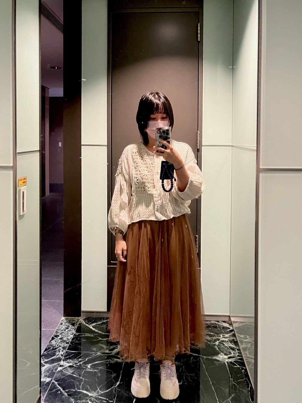 ホワイト系のブルゾンを着用したレディースの冬コーディネートの2枚目の写真