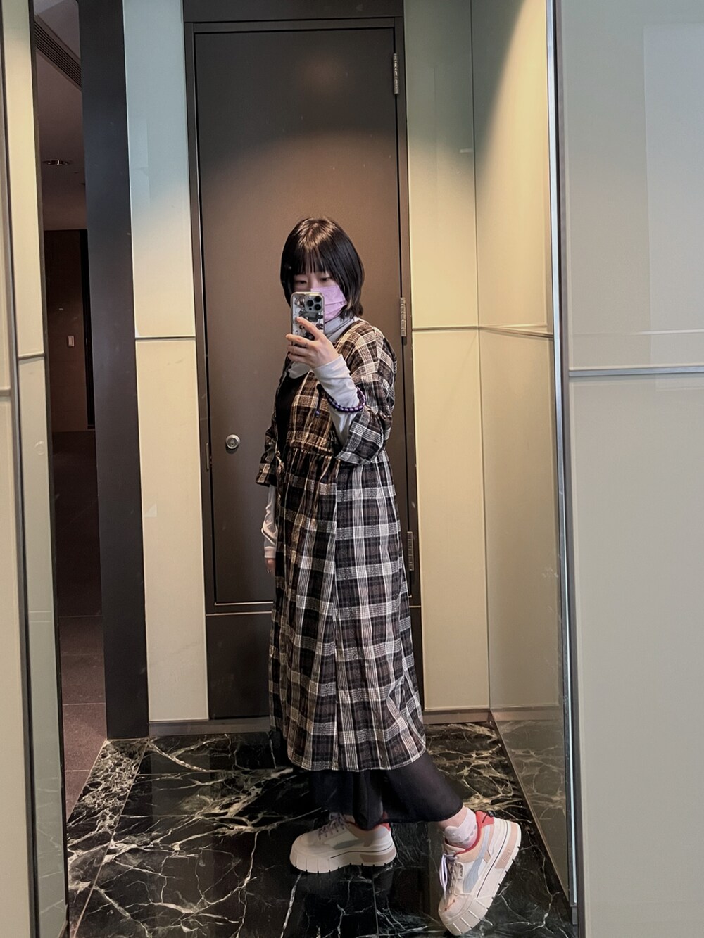 ブラック系のジャケット/アウター、グレー系のトップス、ホワイト系のスニーカーを着用したレディースの冬コーディネートの4枚目の写真