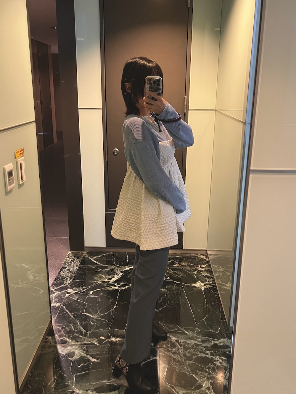 ホワイト系のトップス、ブルー系のパンツ、ブルー系のTシャツ/カットソーを着用したレディースの冬コーディネートの2枚目の写真