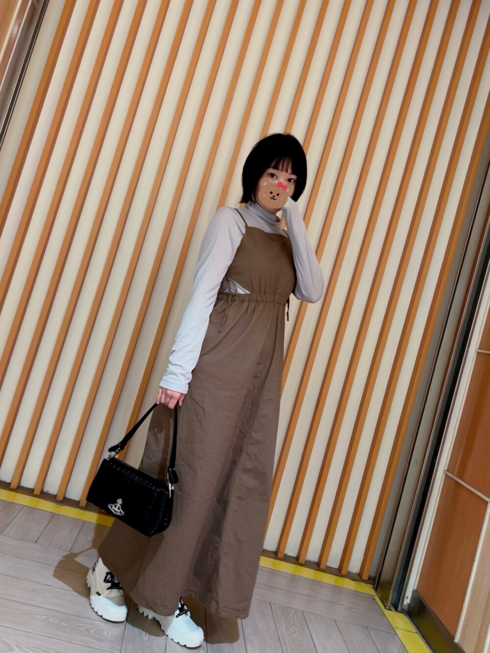 ブラック系のショルダーバッグ、グリーン系のワンピース、グレー系のトップスを着用したレディースの冬コーディネートの2枚目の写真