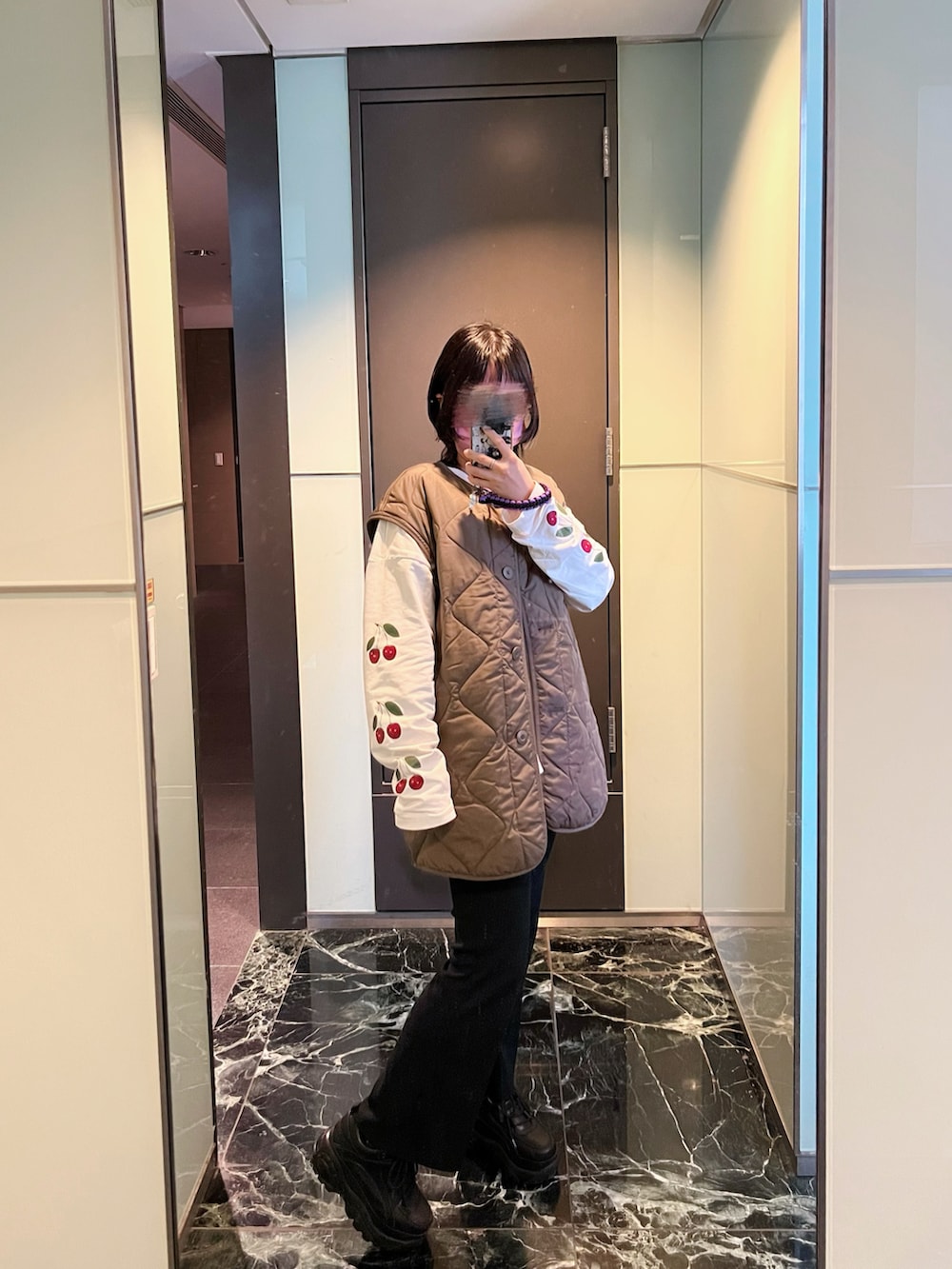 ホワイト系のトップス、ブラック系のチノパンツ、ブラック系のシューズを着用したレディースの冬コーディネートの3枚目の写真