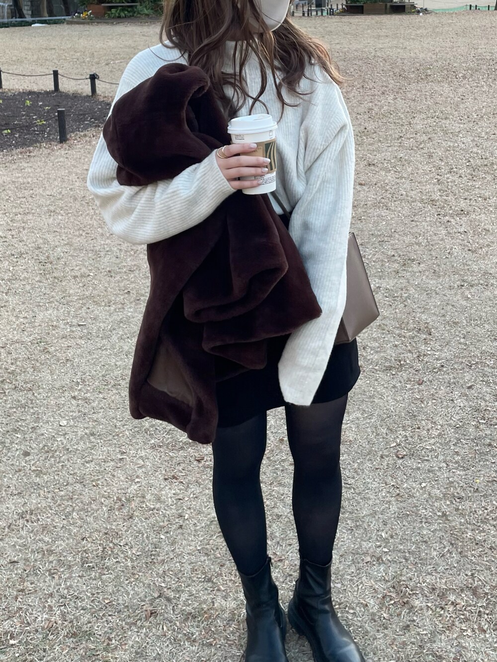 ブラック系のスカート、ブラック系のシューズ、ホワイト系のニット/セーターを着用したレディースの冬コーディネートの2枚目の写真