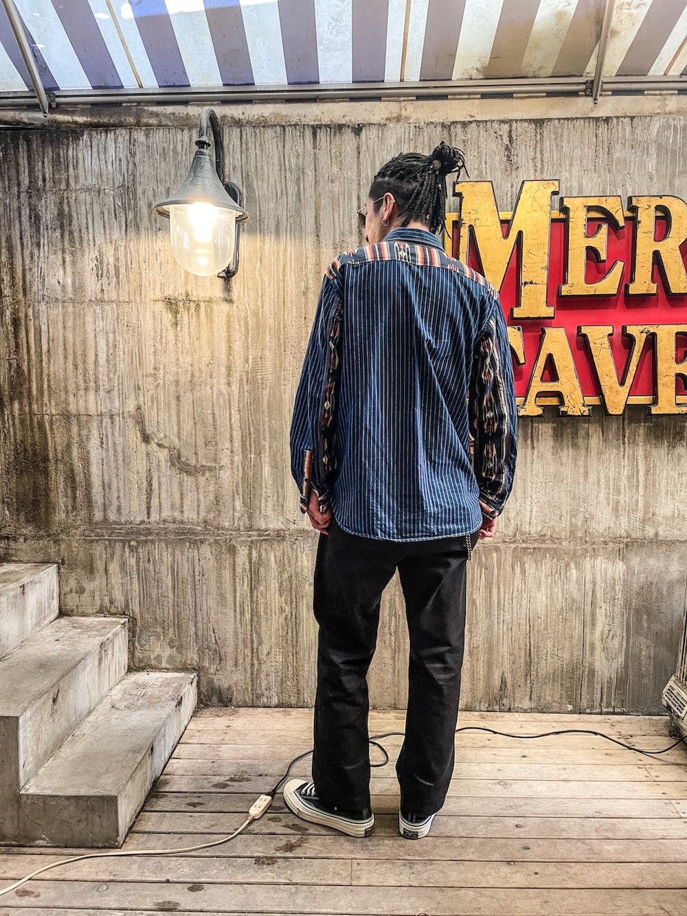 ブルー系のシャツ/ブラウス、ブラック系のチノパンツ、ブラック系のスニーカーを着用したメンズの冬コーディネートの2枚目の写真