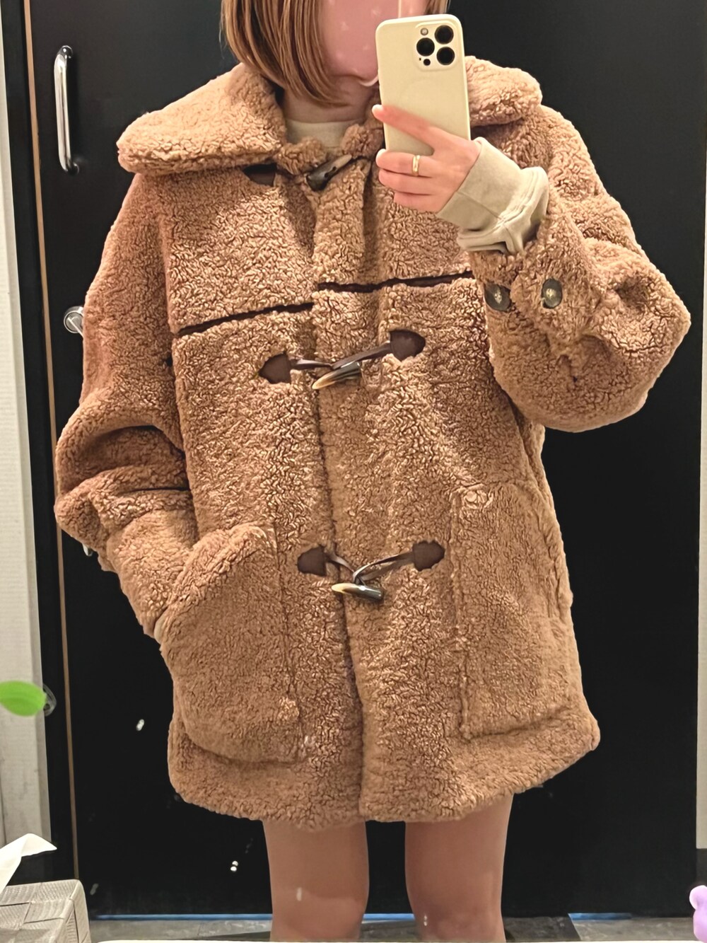 ベージュ系のダッフルコート、ブラウン系のブーツ、ベージュ系のショルダーバッグを着用したレディースの秋コーディネートの2枚目の写真