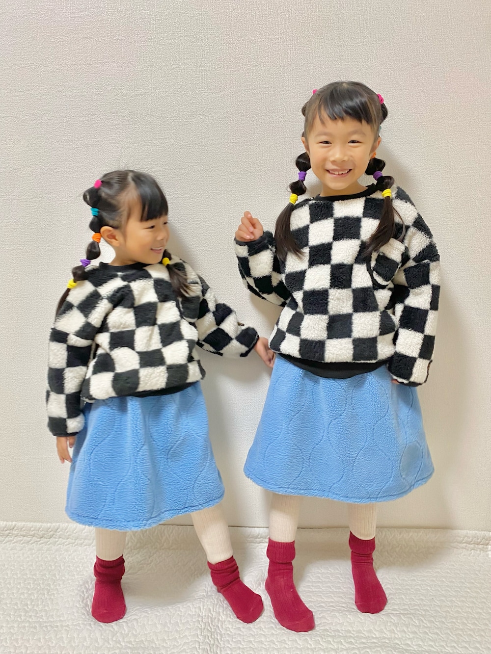 ブルー系のスカート、ブラック系のスウェット、ベージュ系のレギンス/スパッツを着用したキッズの冬コーディネートの2枚目の写真