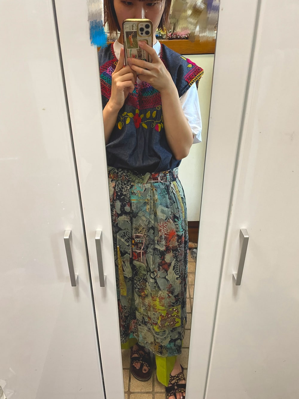 グリーン系のスカート、ブルー系のベスト、ホワイト系のTシャツ/カットソーを着用したレディースの夏コーディネートの2枚目の写真