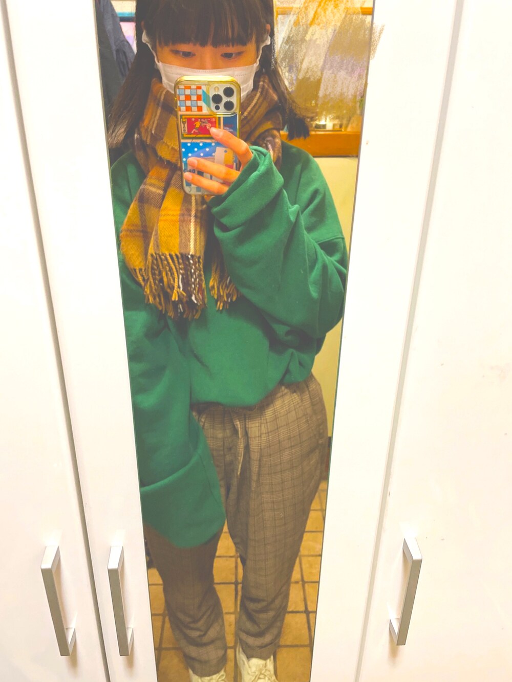 ブラウン系のパンツ、ベージュ系のスニーカー、ホワイト系のブルゾンを着用したレディースの冬コーディネートの2枚目の写真