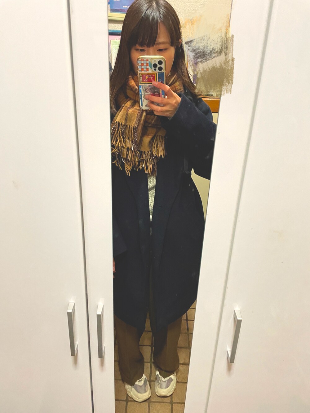 ブラウン系のパンツ、ベージュ系のスニーカー、グレー系のニット/セーターを着用したレディースの冬コーディネートの3枚目の写真