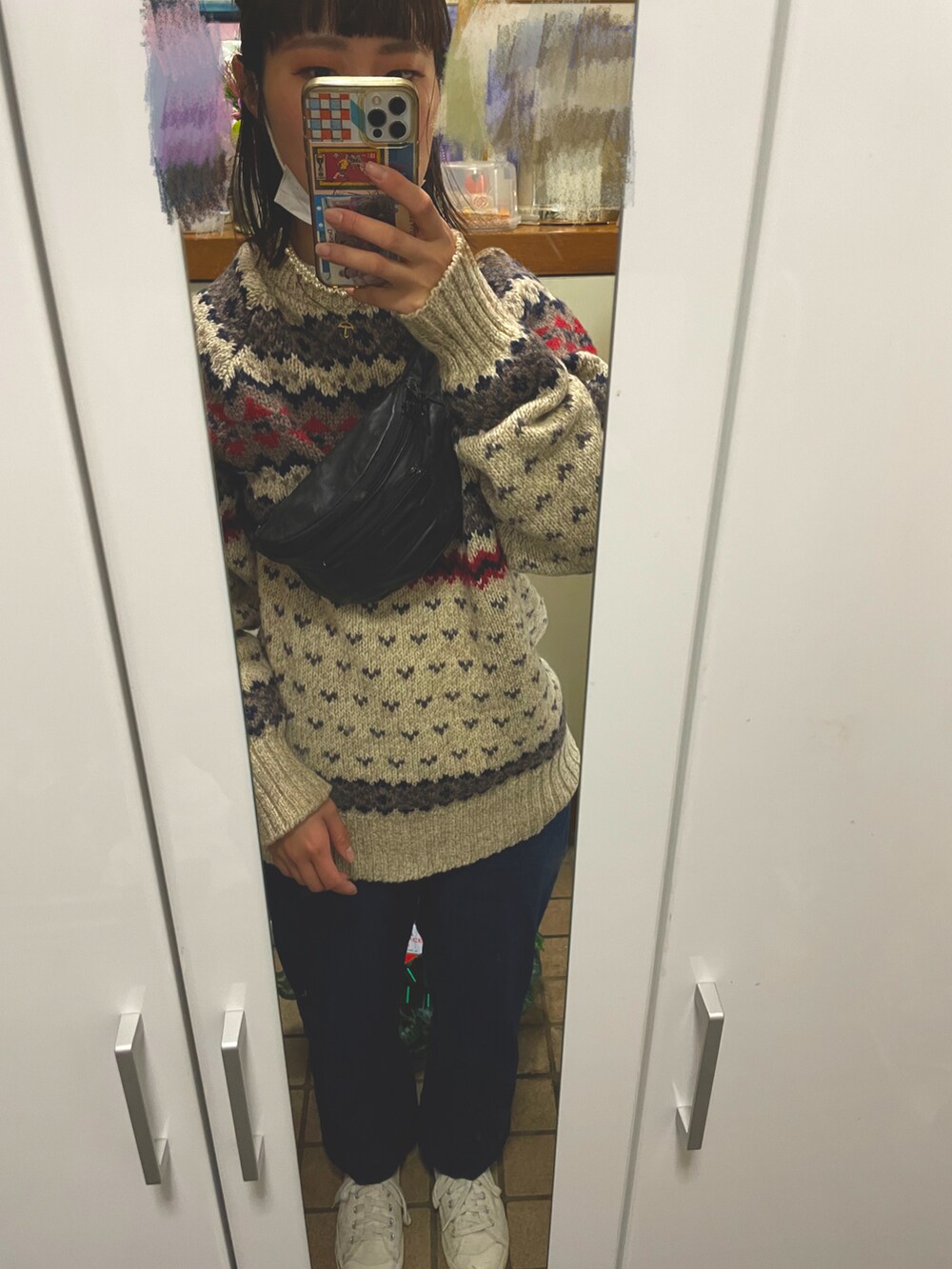 ホワイト系のニット/セーター、ブルー系のデニムパンツ、ホワイト系のスニーカーを着用したレディースの冬コーディネートの2枚目の写真