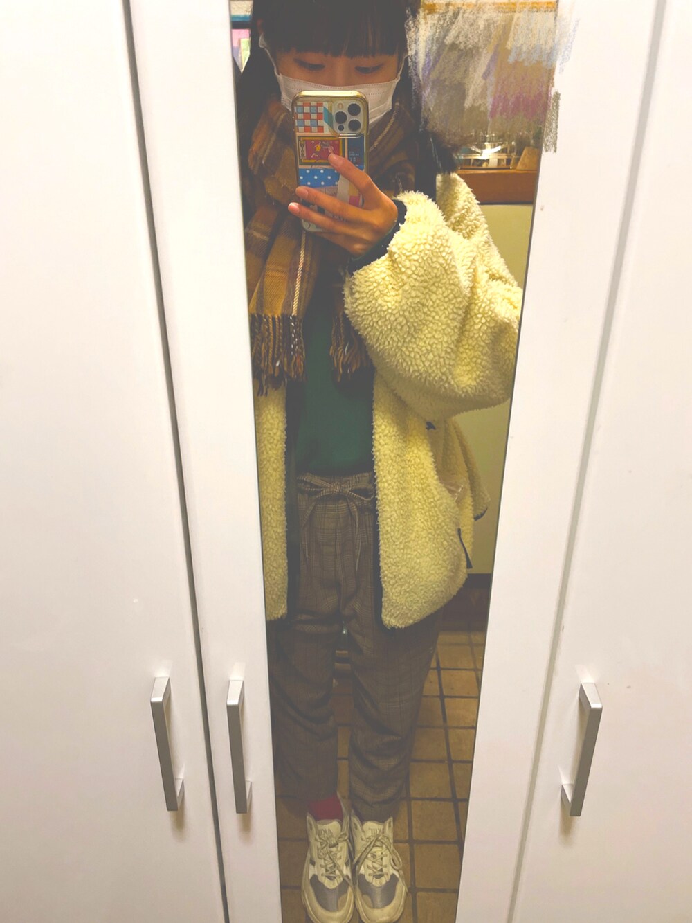 ブラウン系のパンツ、ベージュ系のスニーカー、ホワイト系のブルゾンを着用したレディースの冬コーディネートの3枚目の写真