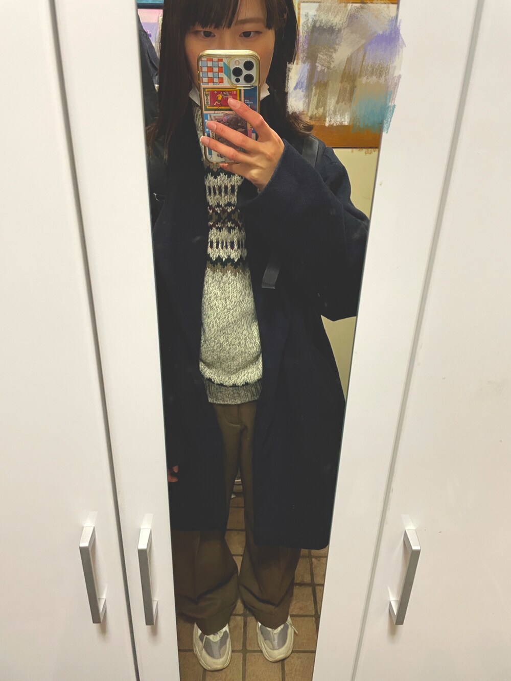 ブラウン系のパンツ、ベージュ系のスニーカー、グレー系のニット/セーターを着用したレディースの冬コーディネートの2枚目の写真