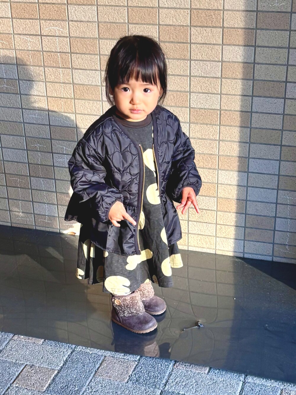 ブラック系のワンピース、ブラック系のブルゾンを着用したキッズの秋コーディネートの2枚目の写真