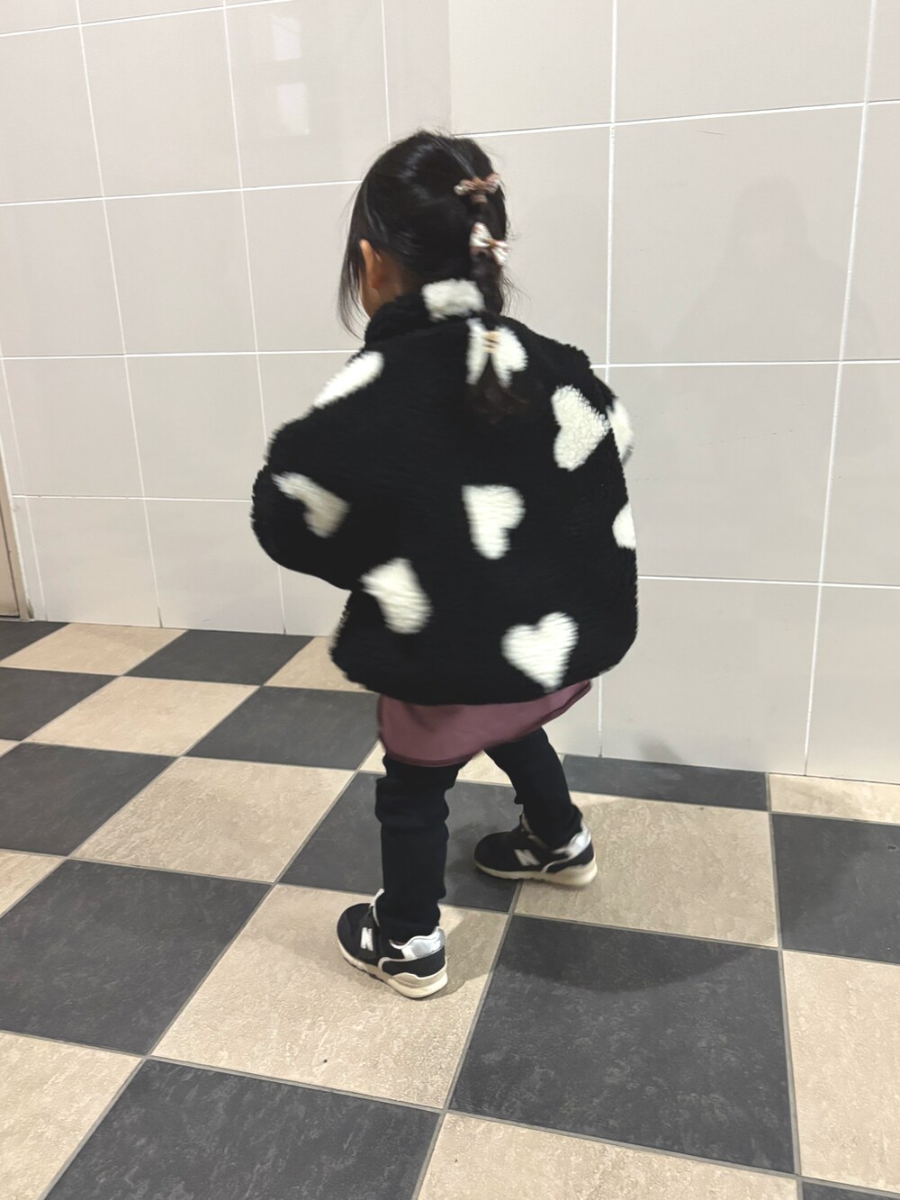 ブラウン系のブルゾン、ピンク系のTシャツ/カットソー、ブラック系のスニーカーを着用したキッズの冬コーディネートの2枚目の写真