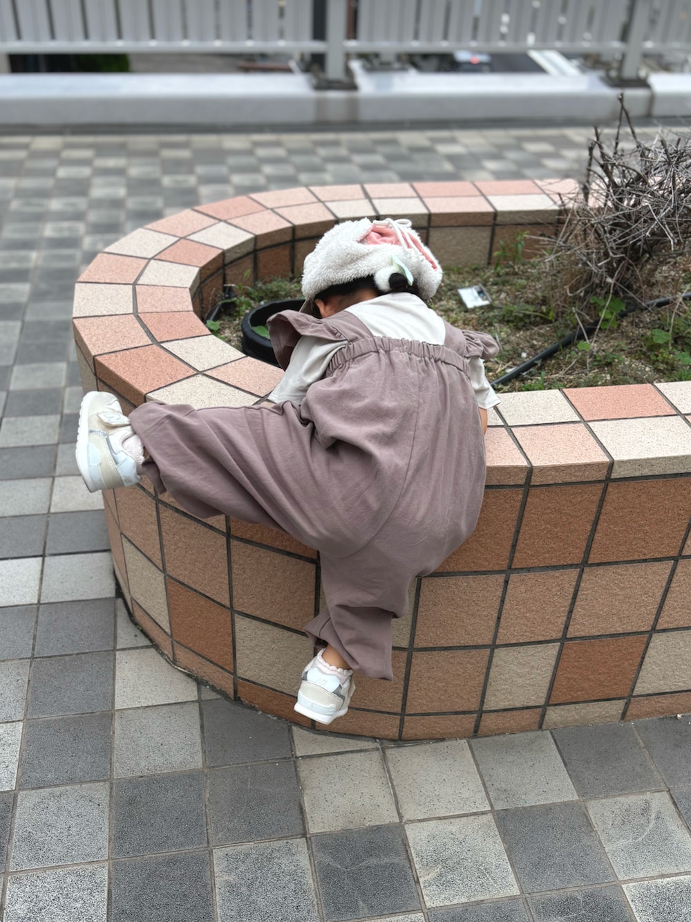 ベージュ系のTシャツ/カットソー、ベージュ系のスニーカー、ピンク系のオールインワン・サロペットを着用したキッズの秋コーディネートの2枚目の写真