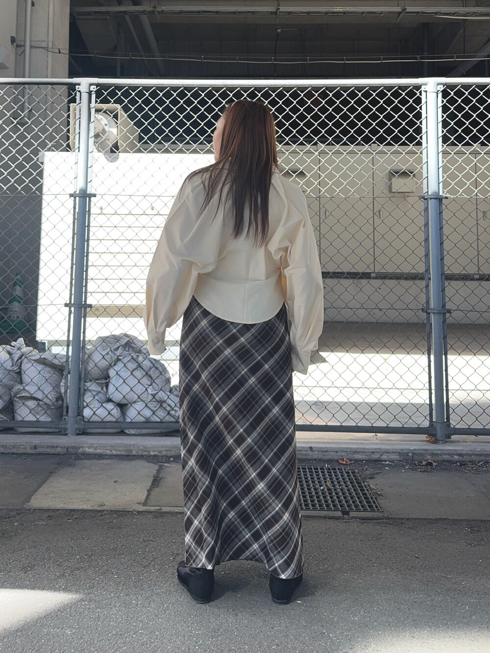 ブラウン系のスカート、ベージュ系のシャツ/ブラウス、ブラック系のスニーカーを着用したレディースの秋コーディネートの3枚目の写真