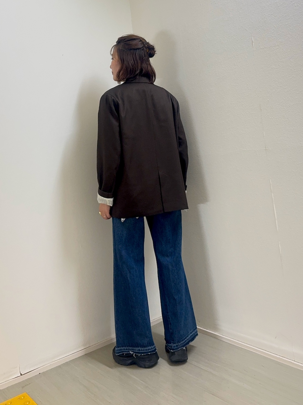 ホワイト系のキャミソール、ブラウン系のその他アウター、ブルー系のデニムパンツを着用したレディースの秋コーディネートの2枚目の写真