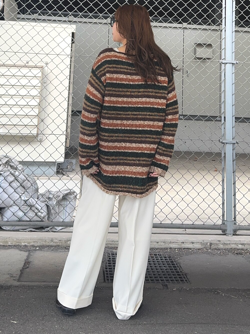 ブラウン系のニット/セーター、ホワイト系のその他パンツ、ブラウン系のローファーを着用したレディースの秋コーディネートの3枚目の写真