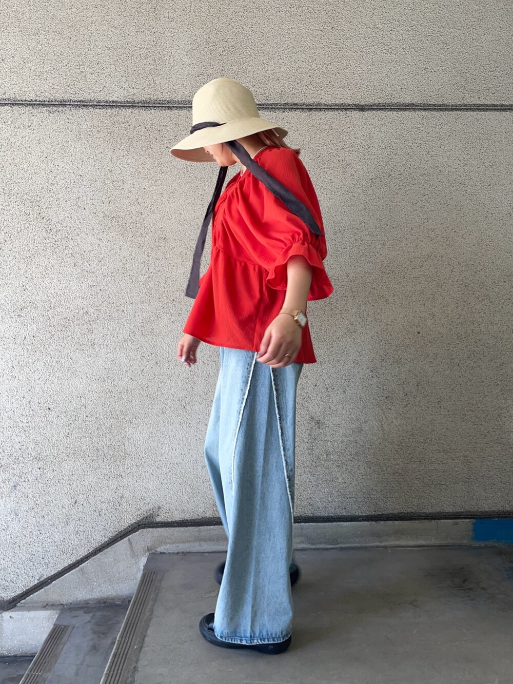レッド系のシャツ/ブラウス、ブルー系のデニムパンツ、ホワイト系のハットを着用したレディースの春コーディネートの3枚目の写真