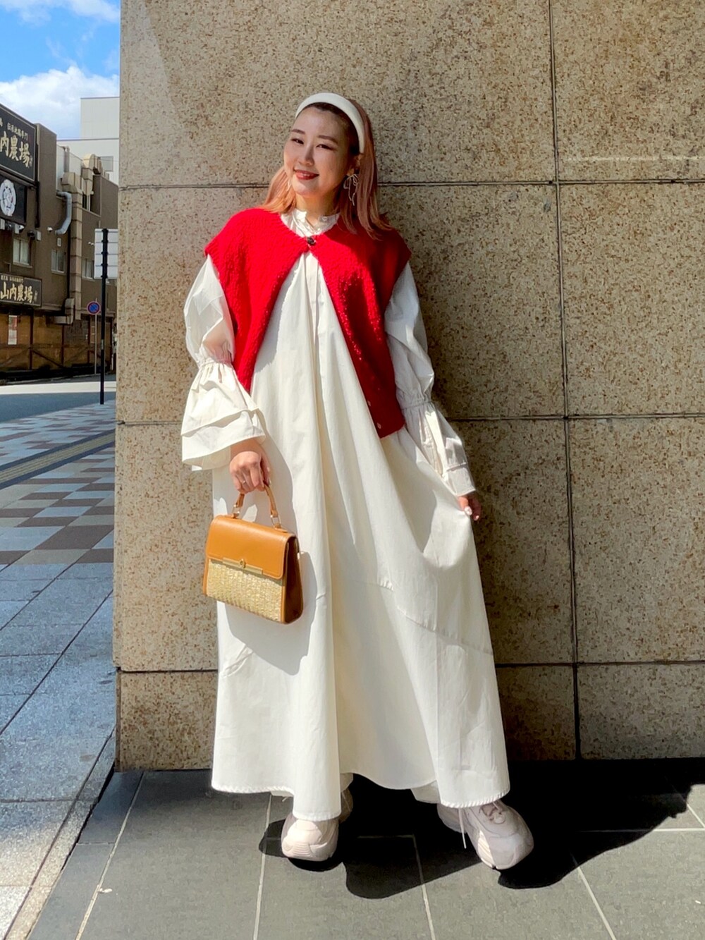 ホワイト系のワンピース、レッド系のニット/セーター、イエロー系のショルダーバッグを着用したレディースの春コーディネートの2枚目の写真