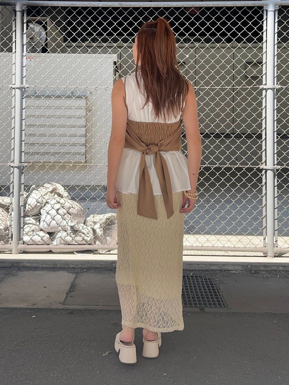 ホワイト系のスカート、ベージュ系のシャツ/ブラウスを着用したレディースの夏コーディネートの3枚目の写真