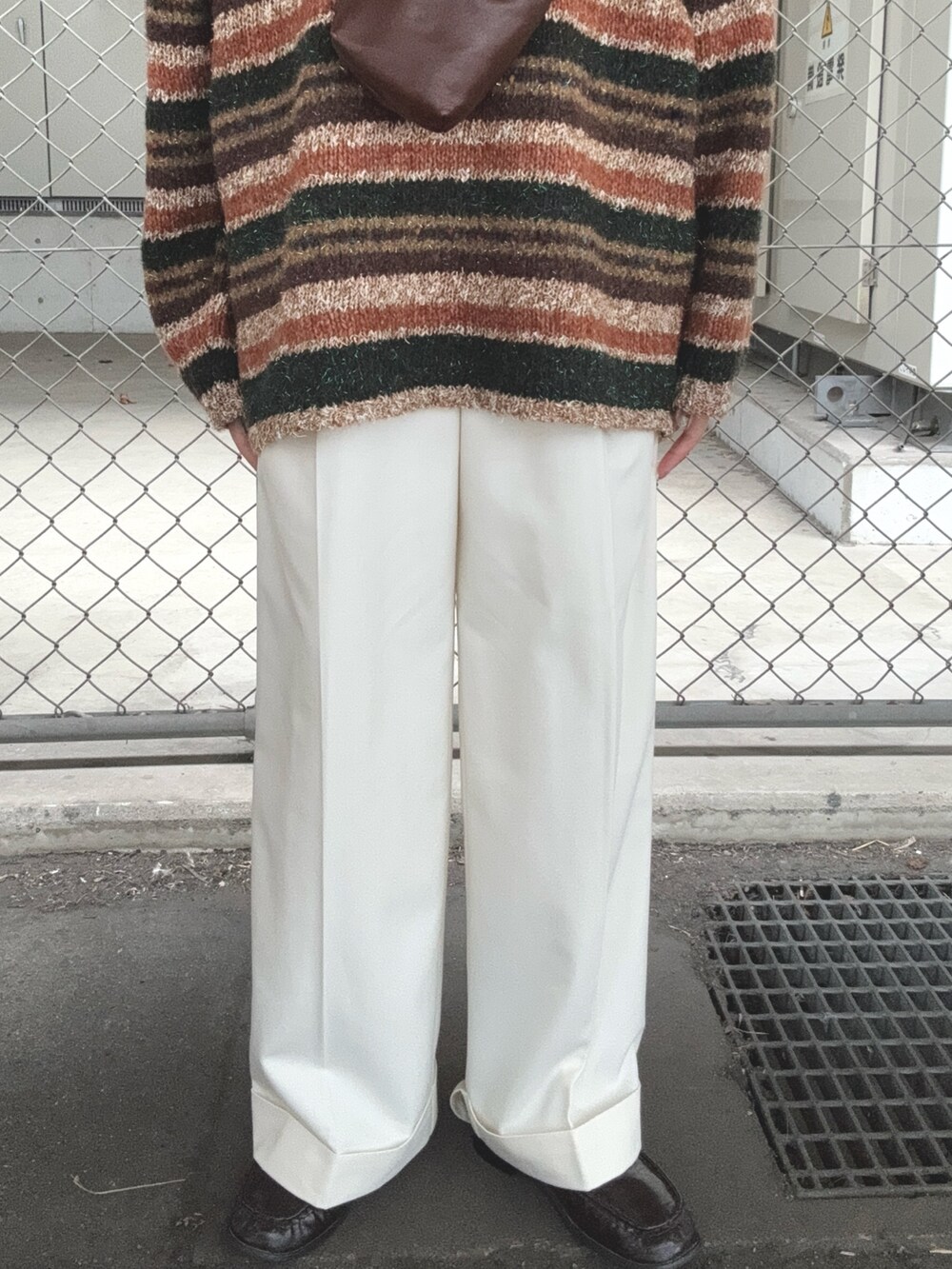 ブラウン系のニット/セーター、ホワイト系のその他パンツ、ブラウン系のローファーを着用したレディースの秋コーディネートの5枚目の写真