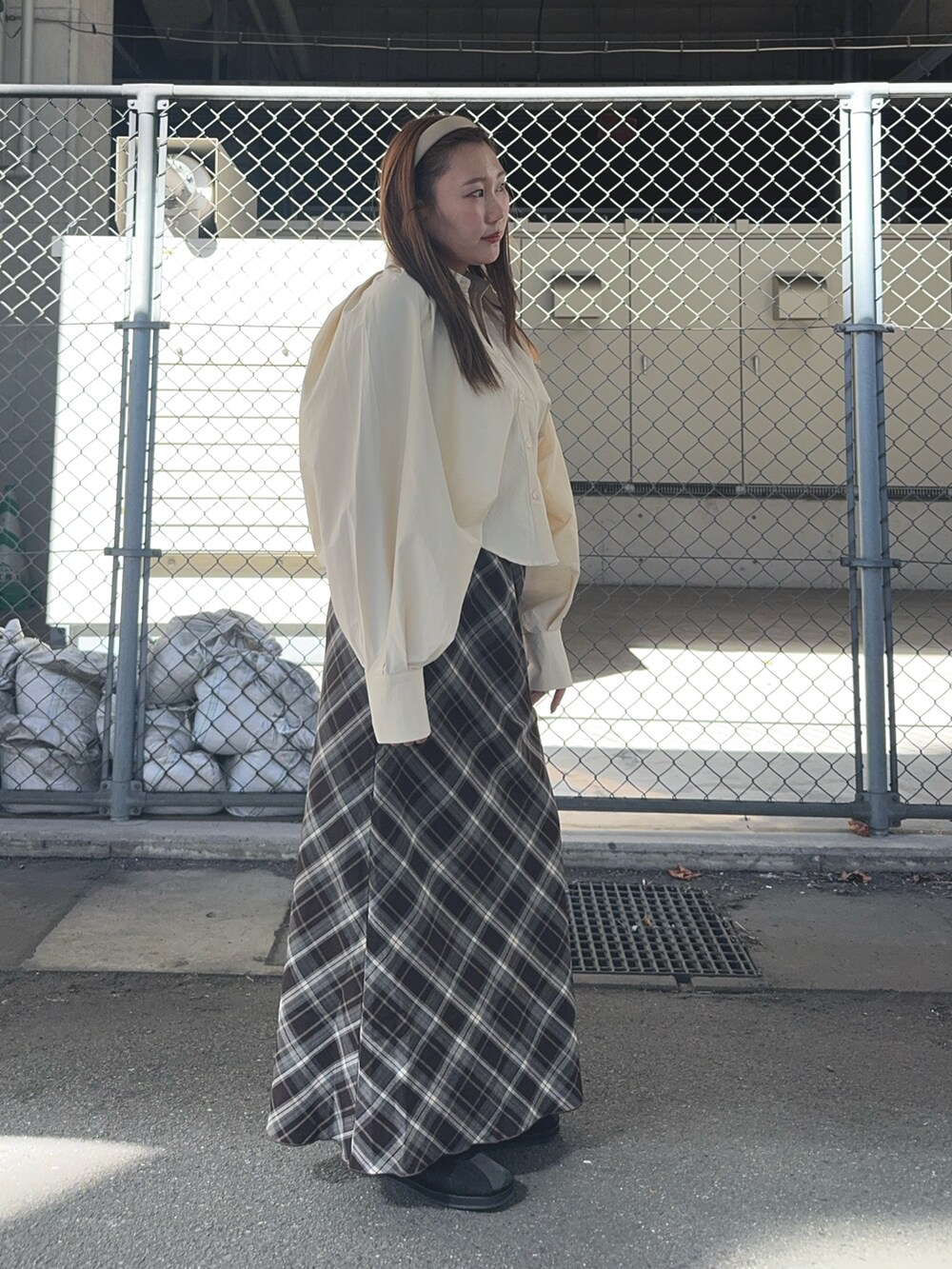 ブラウン系のスカート、ベージュ系のシャツ/ブラウス、ブラック系のスニーカーを着用したレディースの秋コーディネートの8枚目の写真