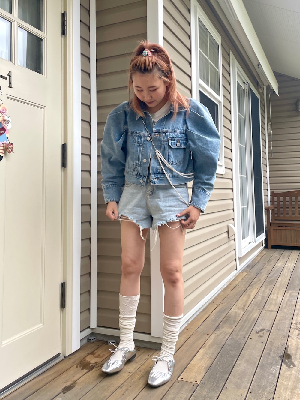 ブルー系のデニムジャケット、シルバー系のネックレスを着用したレディースの春コーディネートの2枚目の写真