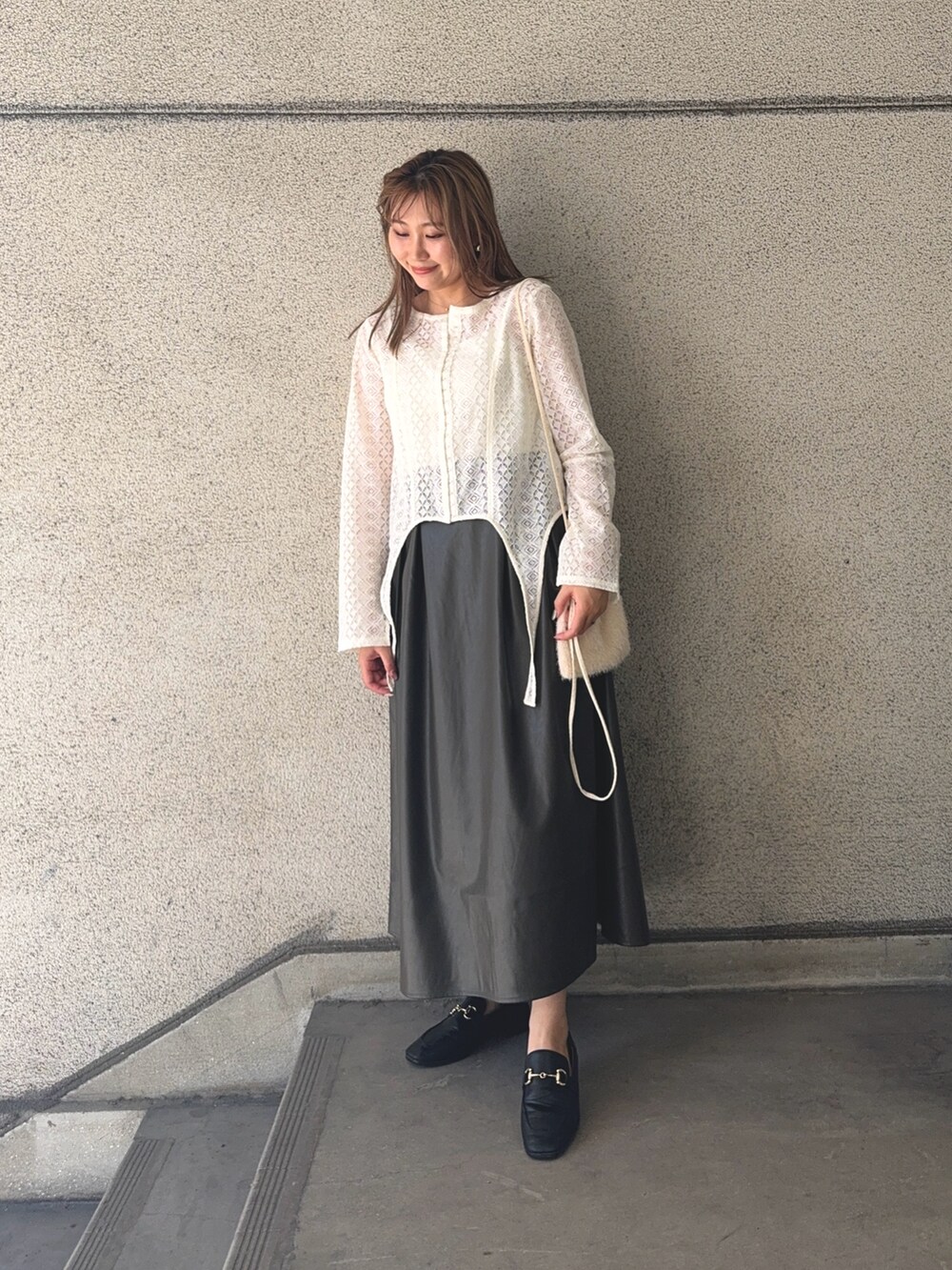 ブラウン系のスカート、ホワイト系のTシャツ/カットソー、ホワイト系のショルダーバッグを着用したレディースの秋コーディネートの2枚目の写真