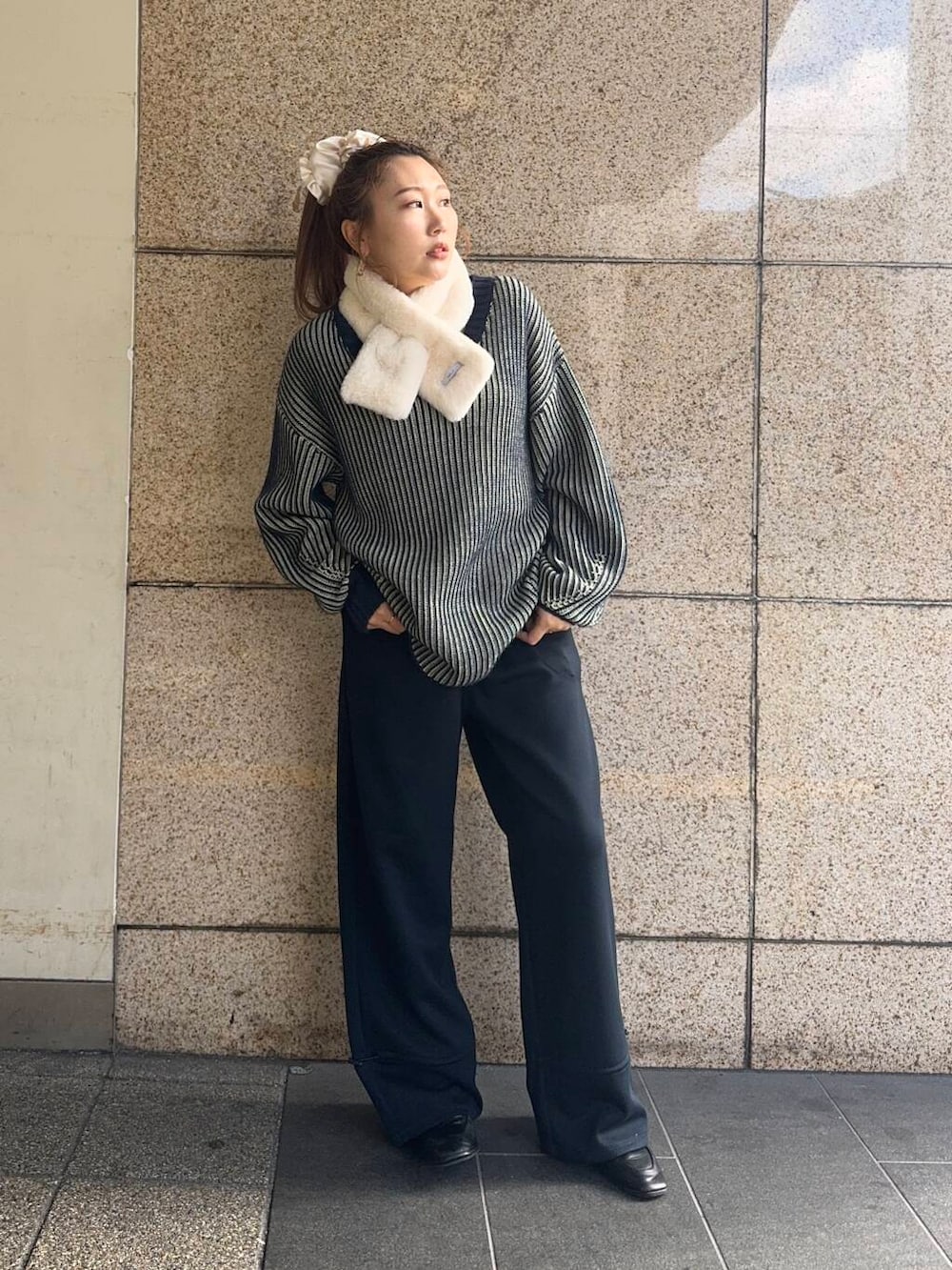 ブルー系のその他パンツ、ブルー系のニット/セーター、ホワイト系のマフラーを着用したレディースの冬コーディネートの2枚目の写真