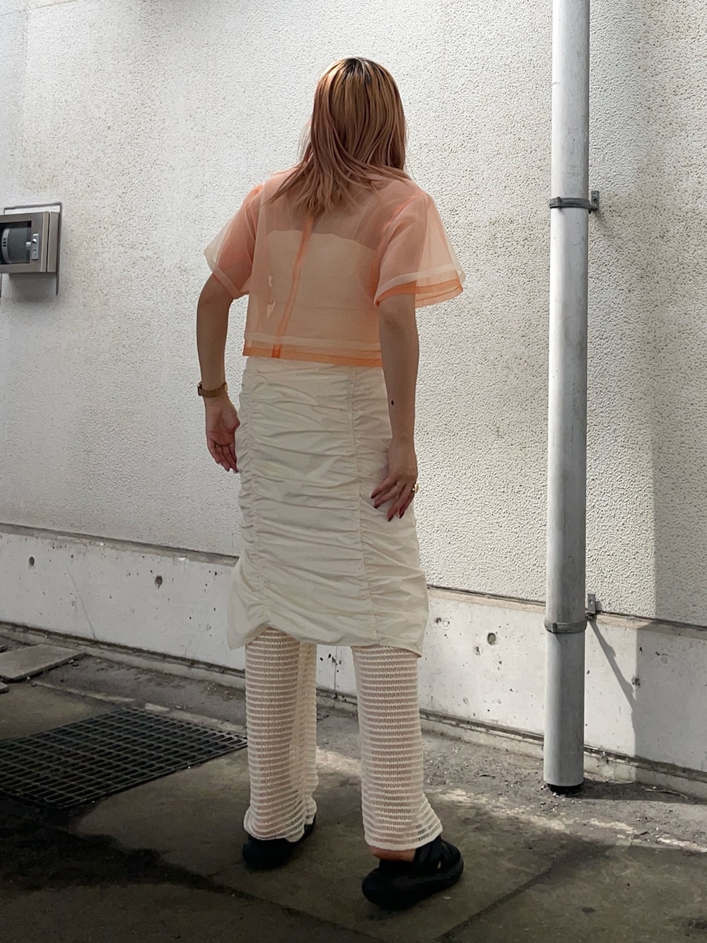 オレンジ系のTシャツ/カットソー、ホワイト系のその他パンツ、その他のピアス（両耳用）を着用したレディースの春コーディネートの3枚目の写真