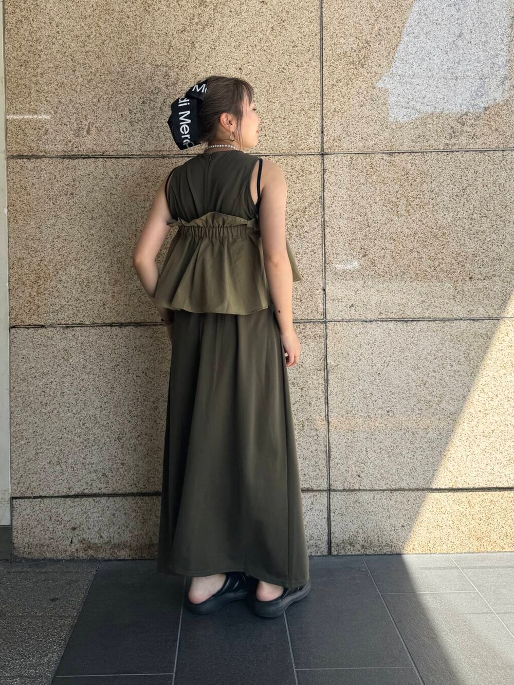 グリーン系のワンピースを着用したレディースの夏コーディネートの2枚目の写真