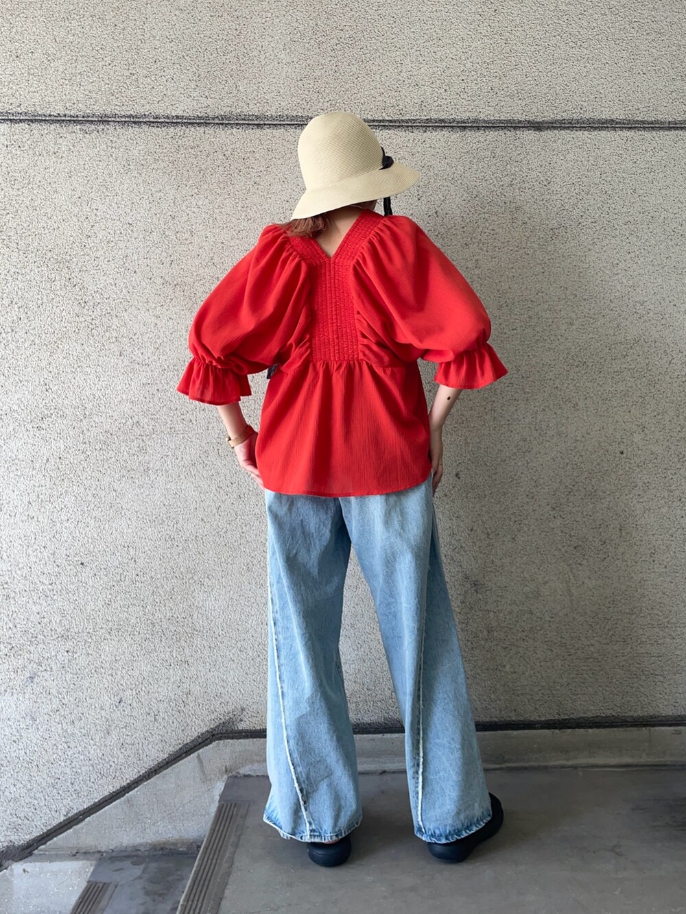 レッド系のシャツ/ブラウス、ブルー系のデニムパンツ、ホワイト系のハットを着用したレディースの春コーディネートの4枚目の写真