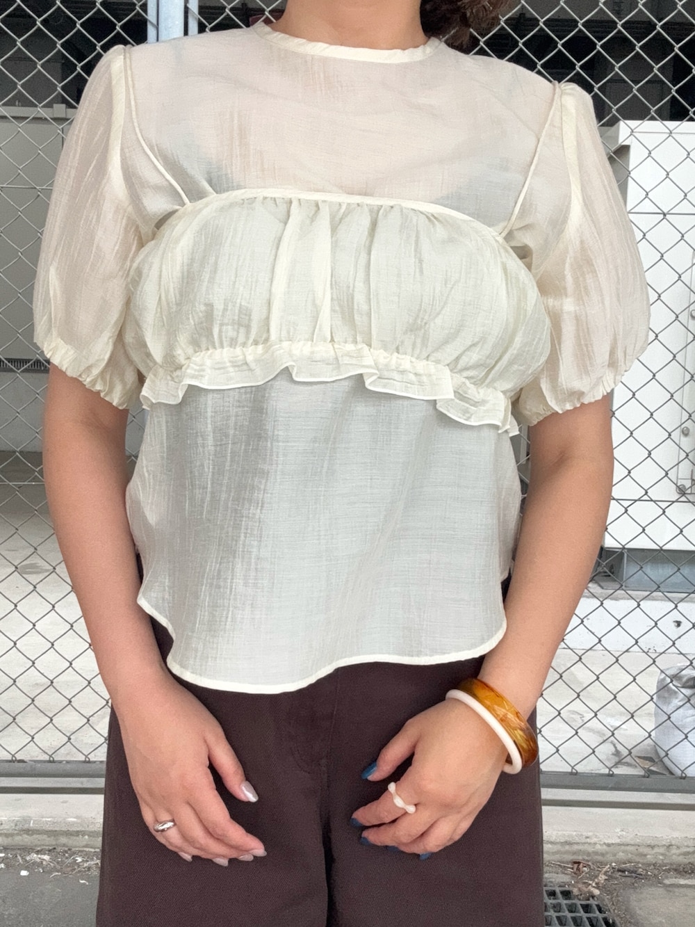 ホワイト系のシャツ/ブラウス、ブラウン系のその他パンツ、ブラウン系のバングル/リストバンドを着用したレディースの春コーディネートの4枚目の写真