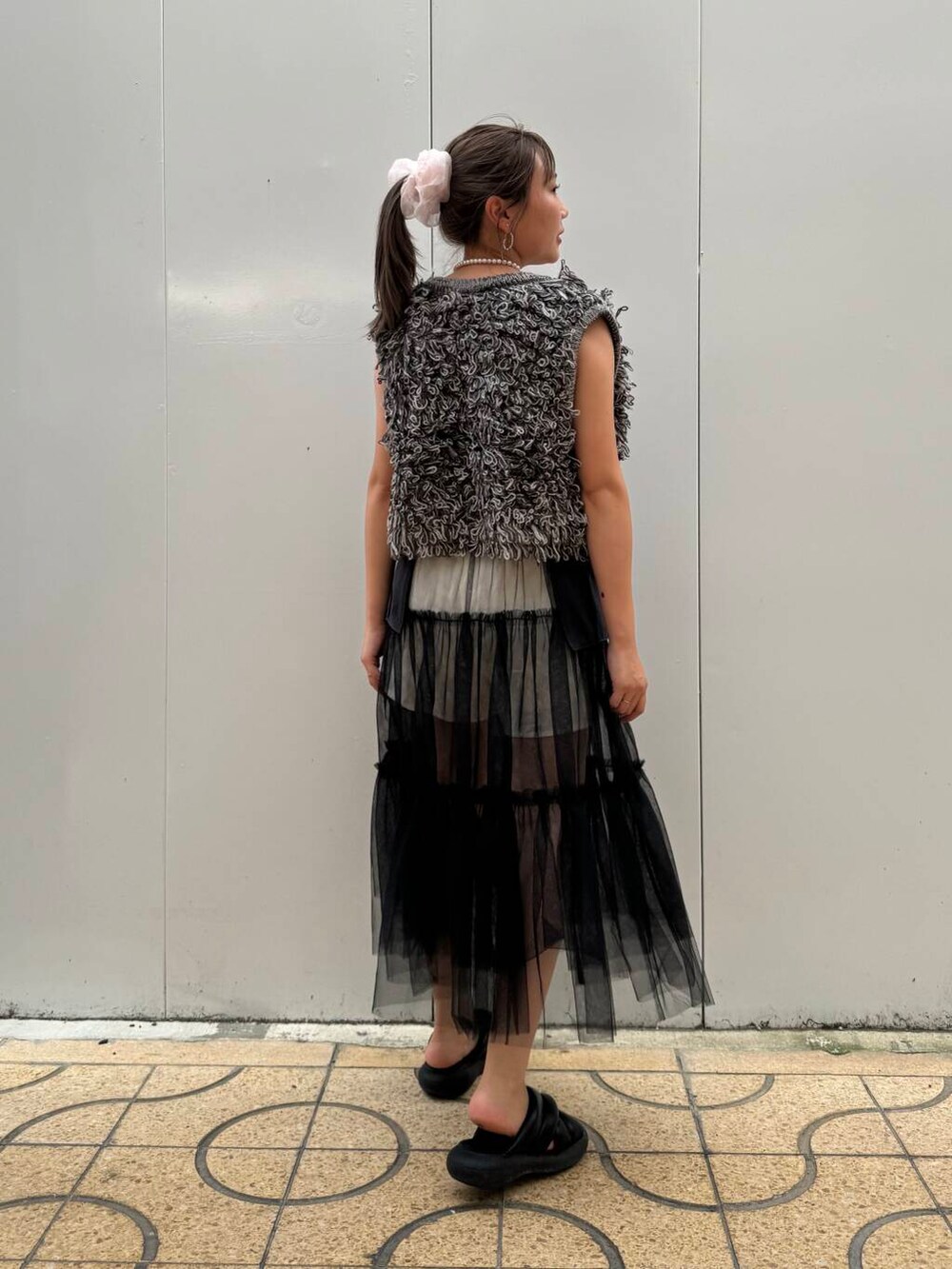 グレー系のスカート、グレー系のベストを着用したレディースの夏コーディネートの4枚目の写真