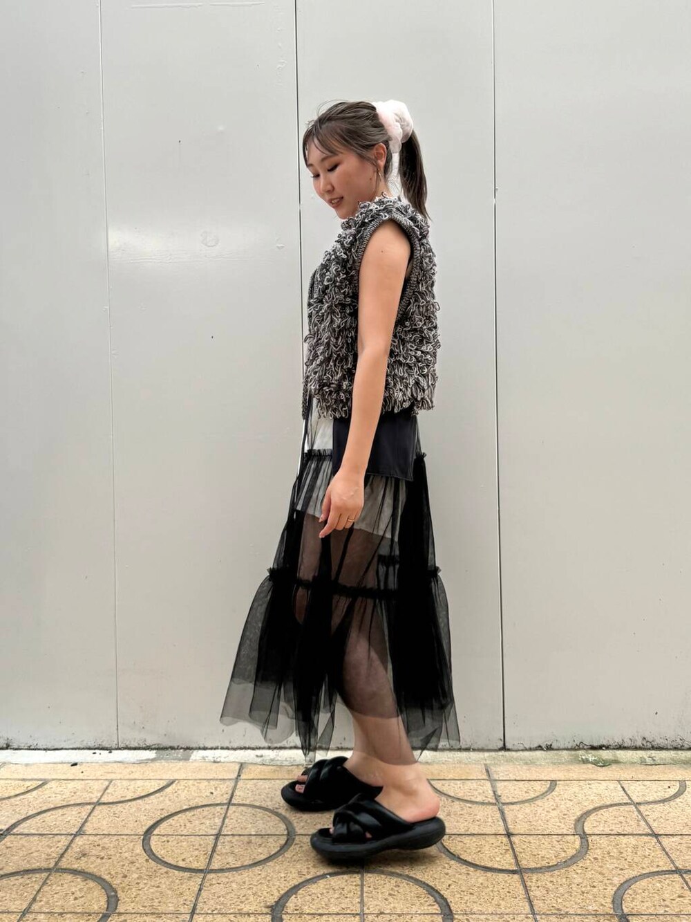 グレー系のスカート、グレー系のベストを着用したレディースの夏コーディネートの3枚目の写真