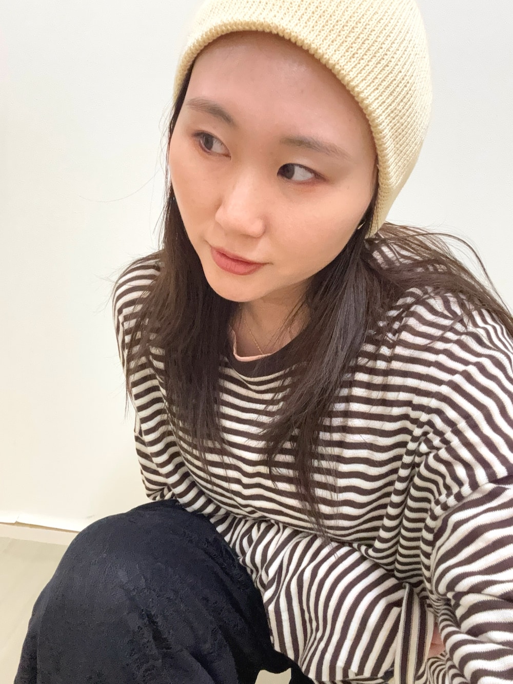 ブラウン系のニット/セーター、ブラック系のその他パンツ、ホワイト系のニットキャップ/ビーニーを着用したレディースの春コーディネートの6枚目の写真