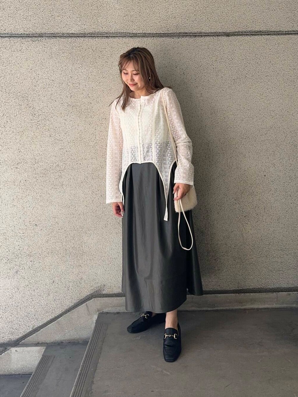 ホワイト系のショルダーバッグ、ホワイト系のTシャツ/カットソー、ブラウン系のスカートを着用したレディースの秋コーディネートの3枚目の写真