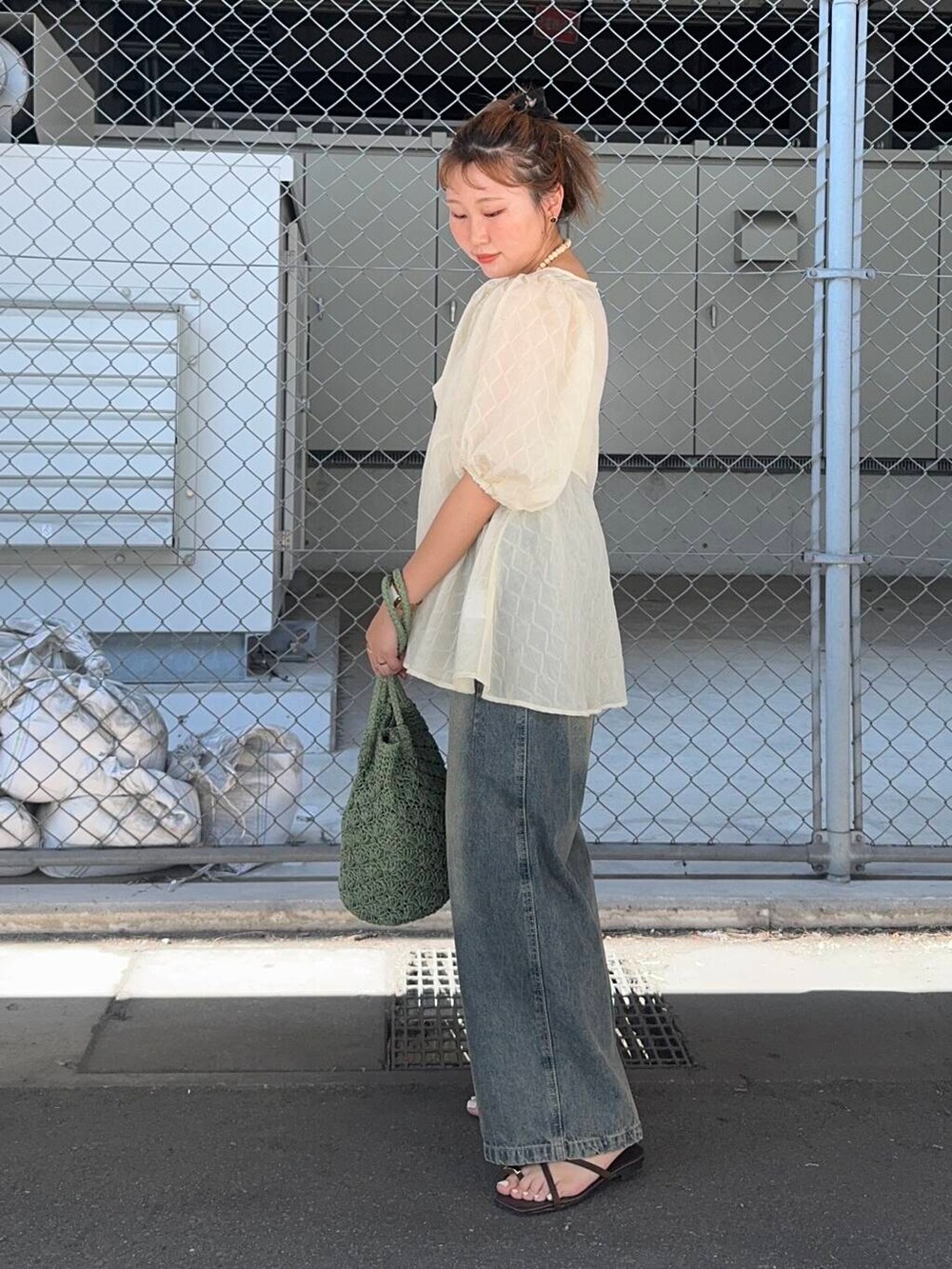 ブルー系のデニムパンツ、グリーン系のトートバッグ、ホワイト系のシャツ/ブラウスを着用したレディースの夏コーディネートの2枚目の写真