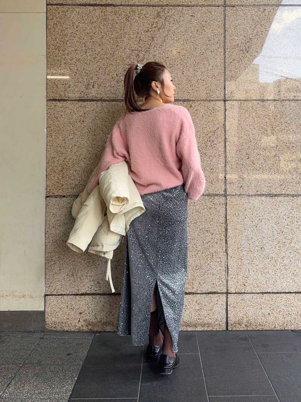 グレー系のスカート、ホワイト系のダウンジャケット/コート、ピンク系のニット/セーターを着用したレディースの冬コーディネートの5枚目の写真
