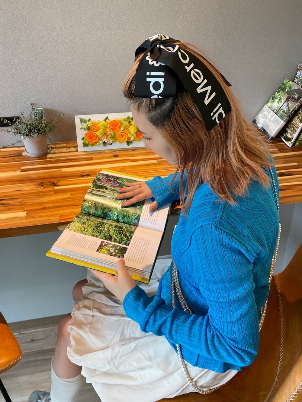 ブルー系のニット/セーター、シルバー系のネックレスを着用したレディースの春コーディネートの4枚目の写真