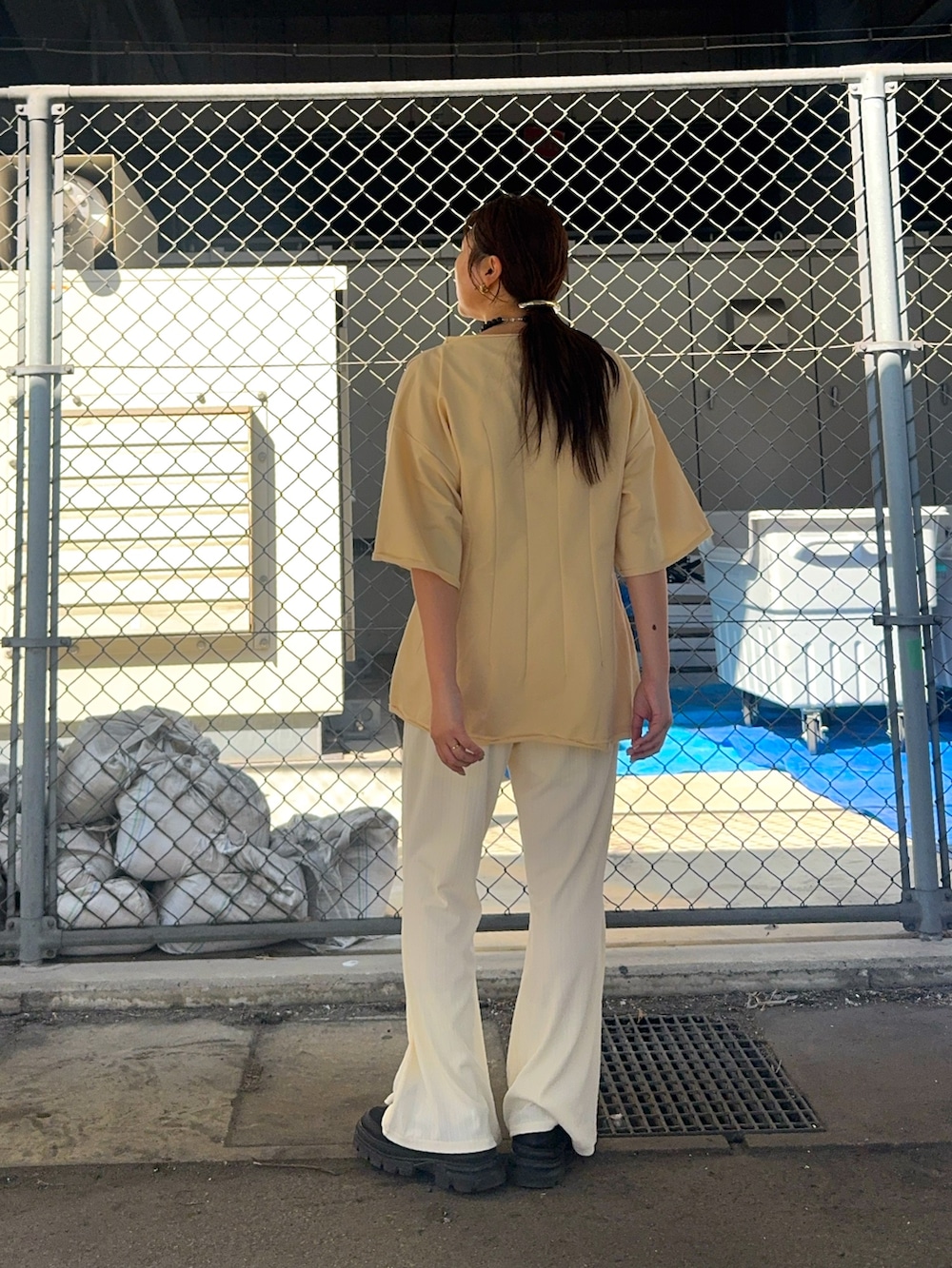 ホワイト系のその他パンツ、イエロー系のTシャツ/カットソー、ブラック系のスニーカーを着用したレディースの春コーディネートの2枚目の写真