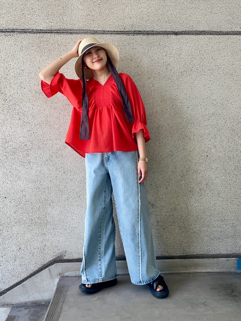 レッド系のシャツ/ブラウス、ブルー系のデニムパンツ、ホワイト系のハットを着用したレディースの春コーディネートの2枚目の写真