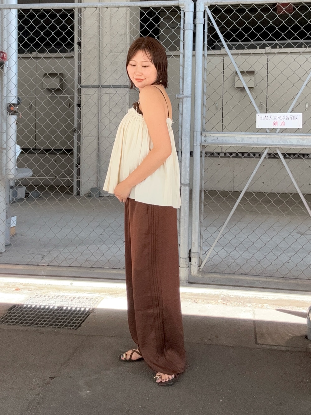 ホワイト系のその他トップス、ブラウン系のその他パンツ、ブラウン系のブレスレットを着用したレディースの夏コーディネートの2枚目の写真