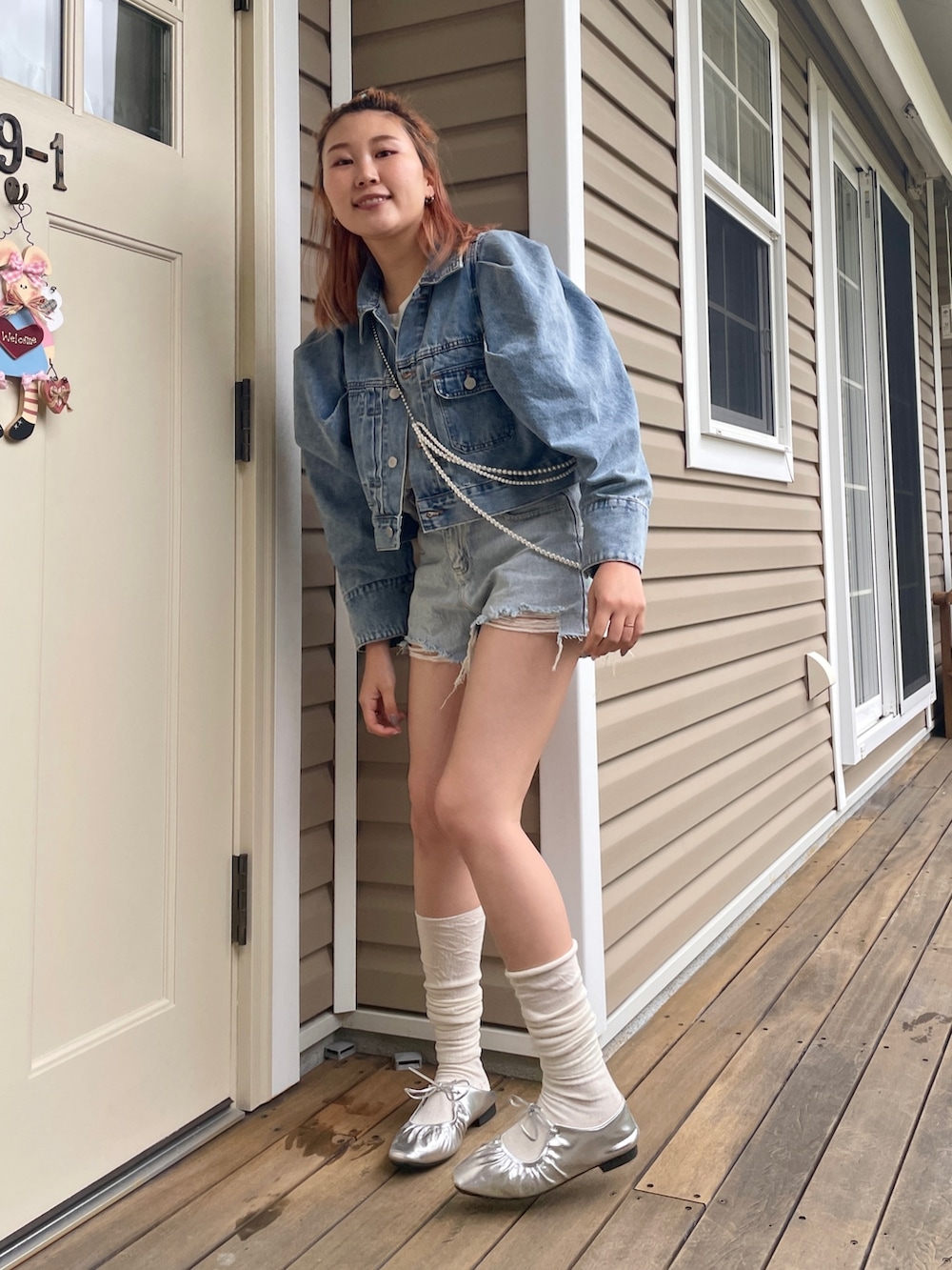 ブルー系のデニムジャケット、シルバー系のネックレスを着用したレディースの春コーディネートの3枚目の写真