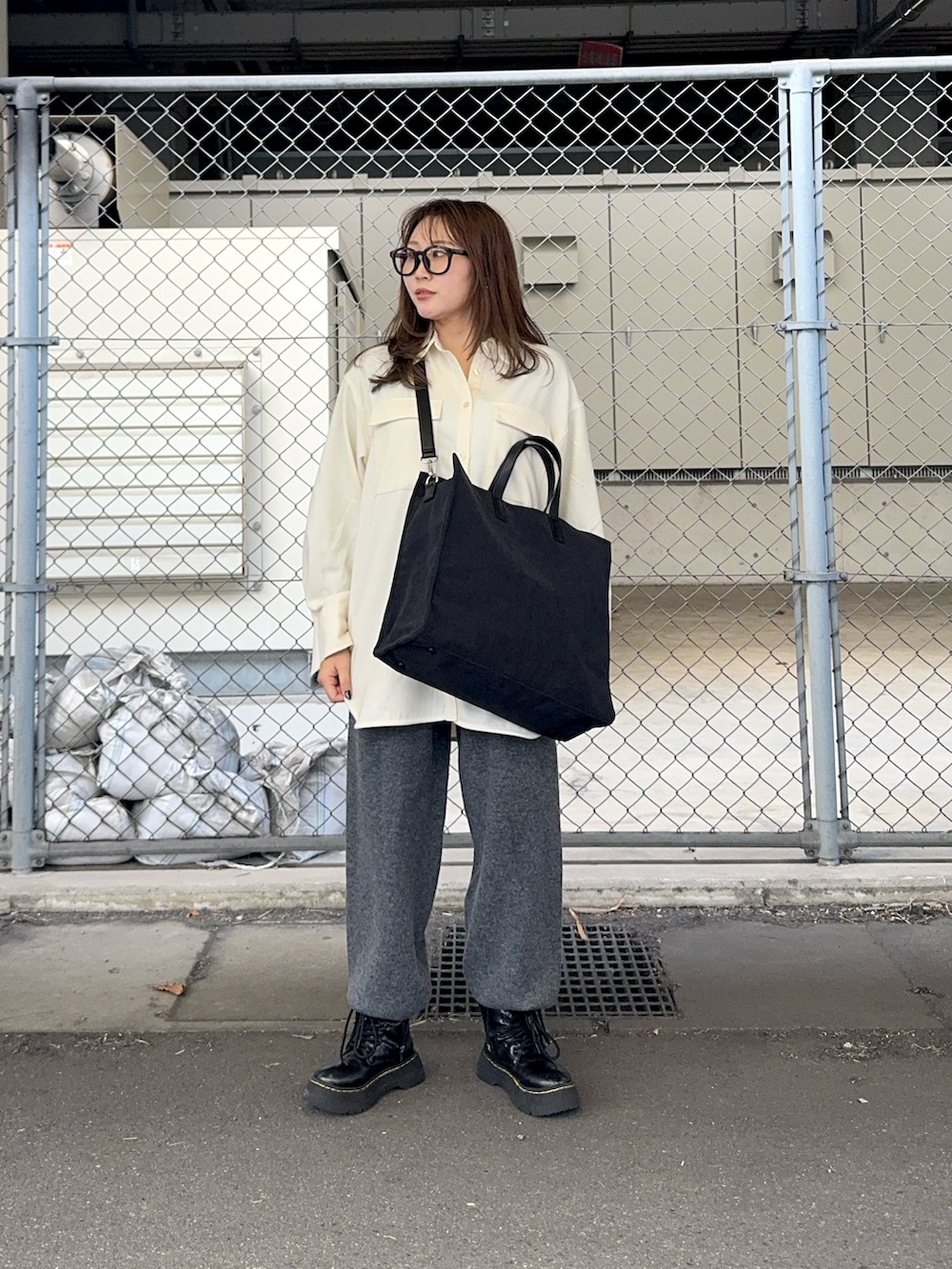 グレー系のその他パンツ、ホワイト系のシャツ/ブラウス、グレー系のトートバッグを着用したレディースの冬コーディネートの2枚目の写真