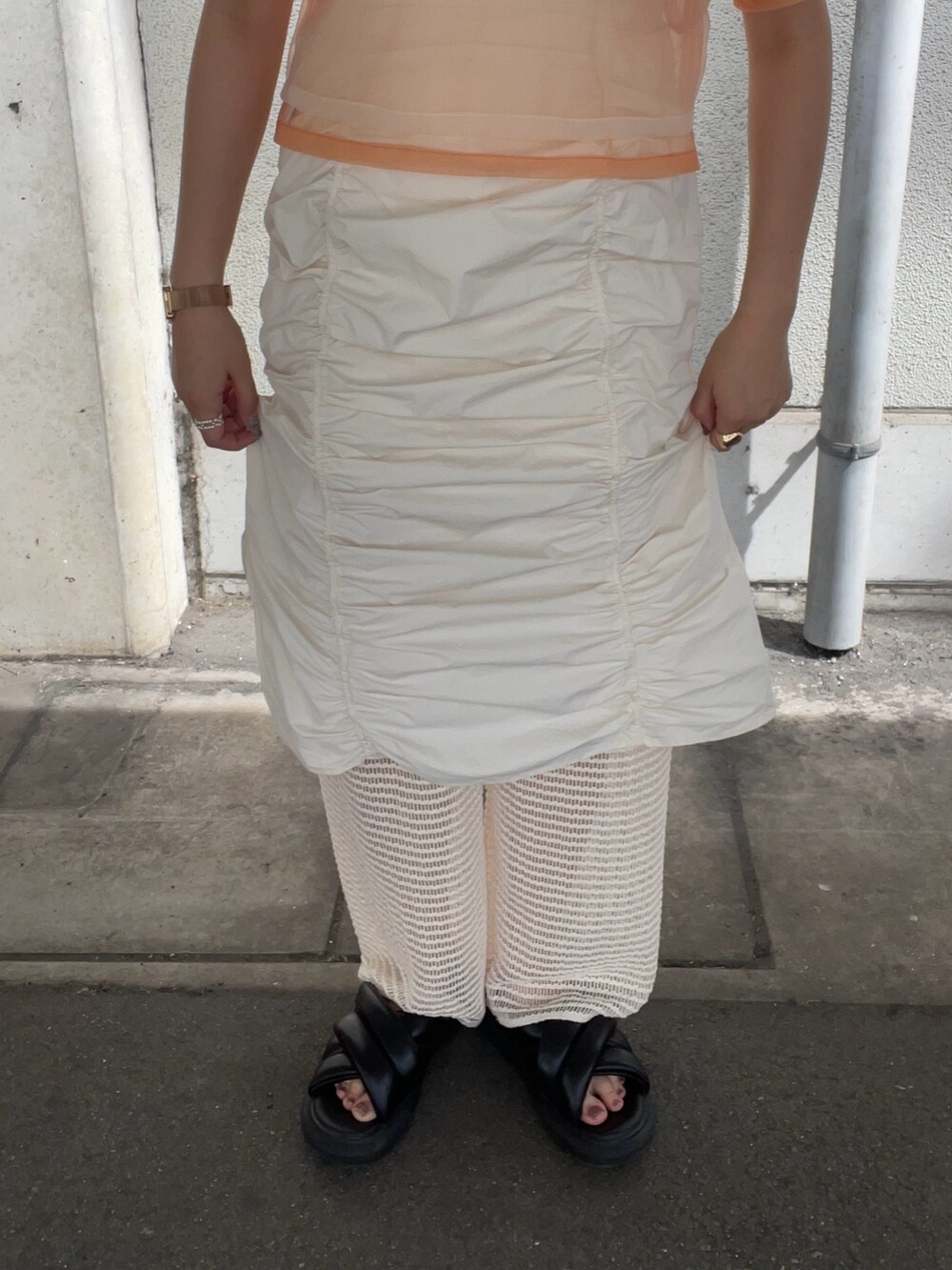 オレンジ系のTシャツ/カットソー、ホワイト系のその他パンツ、その他のピアス（両耳用）を着用したレディースの春コーディネートの5枚目の写真