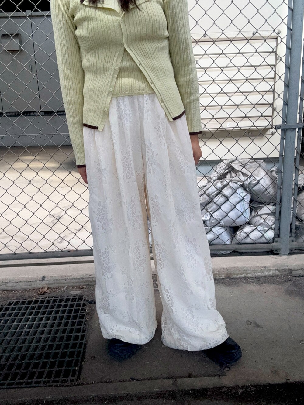 グリーン系のニット/セーター、ホワイト系のその他パンツ、ブラウン系のニットキャップ/ビーニーを着用したレディースの冬コーディネートの4枚目の写真