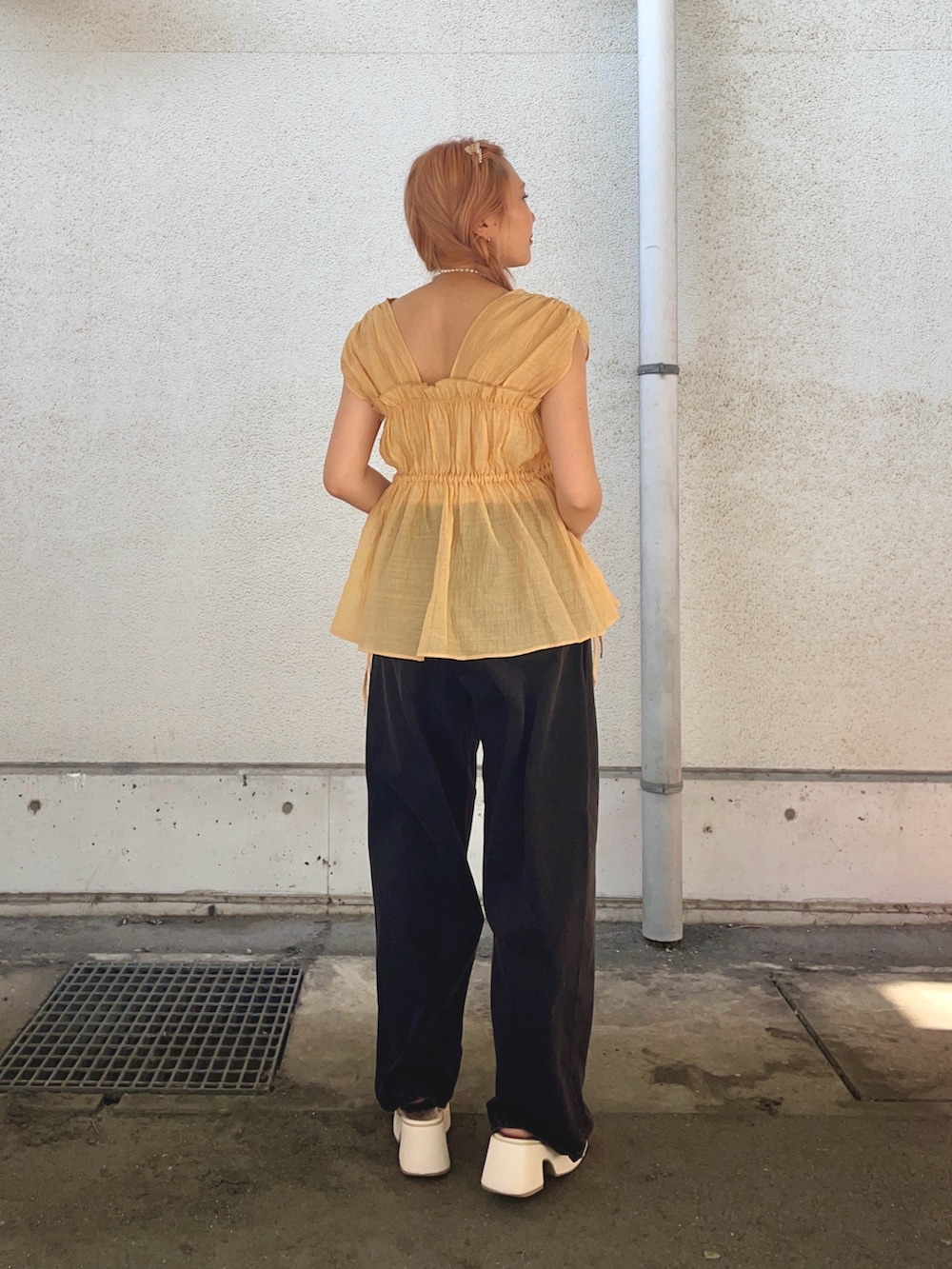 オレンジ系のシャツ/ブラウス、ブラック系のデニムパンツを着用したレディースの夏コーディネートの4枚目の写真