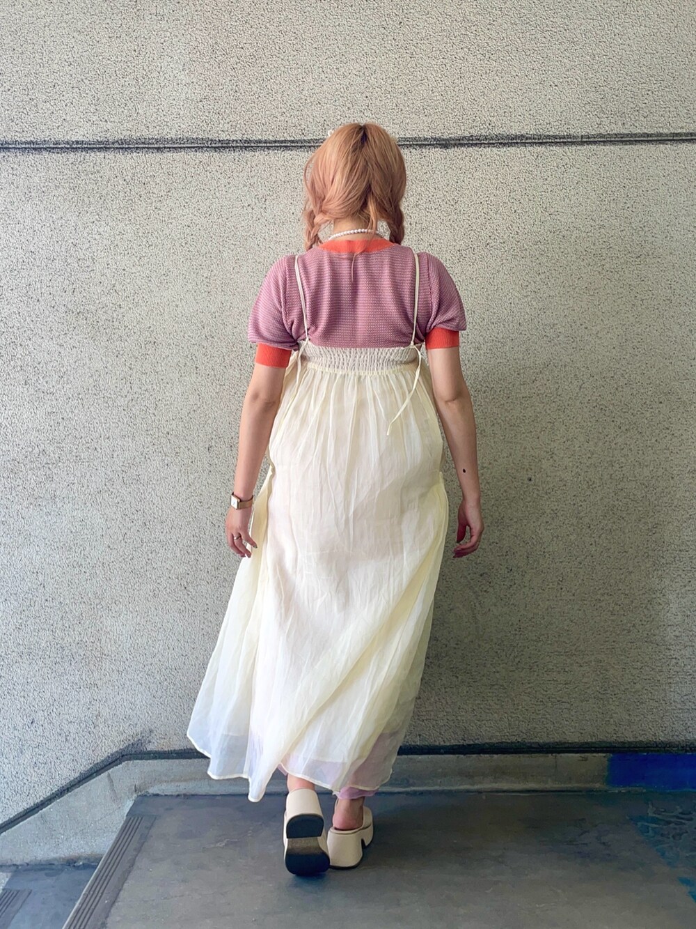 ホワイト系のワンピース、オレンジ系のニット/セーターを着用したレディースの夏コーディネートの4枚目の写真