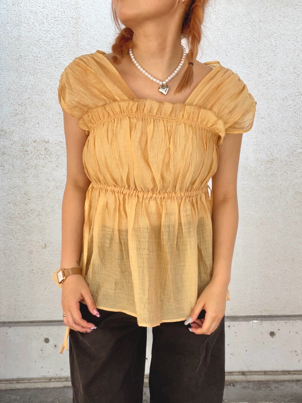 オレンジ系のシャツ/ブラウス、ブラック系のデニムパンツを着用したレディースの夏コーディネートの5枚目の写真